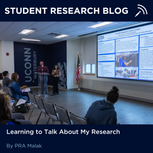 Text reads: Student Research Blog with "Learning to Talk about My Research by PRA Malak" at the bottom. Image in the middle depicts two people presenting at a conference.