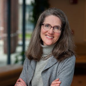 Shareen Hertel, a faculty member, with brown hair and glasses looking at the camera and smiling.